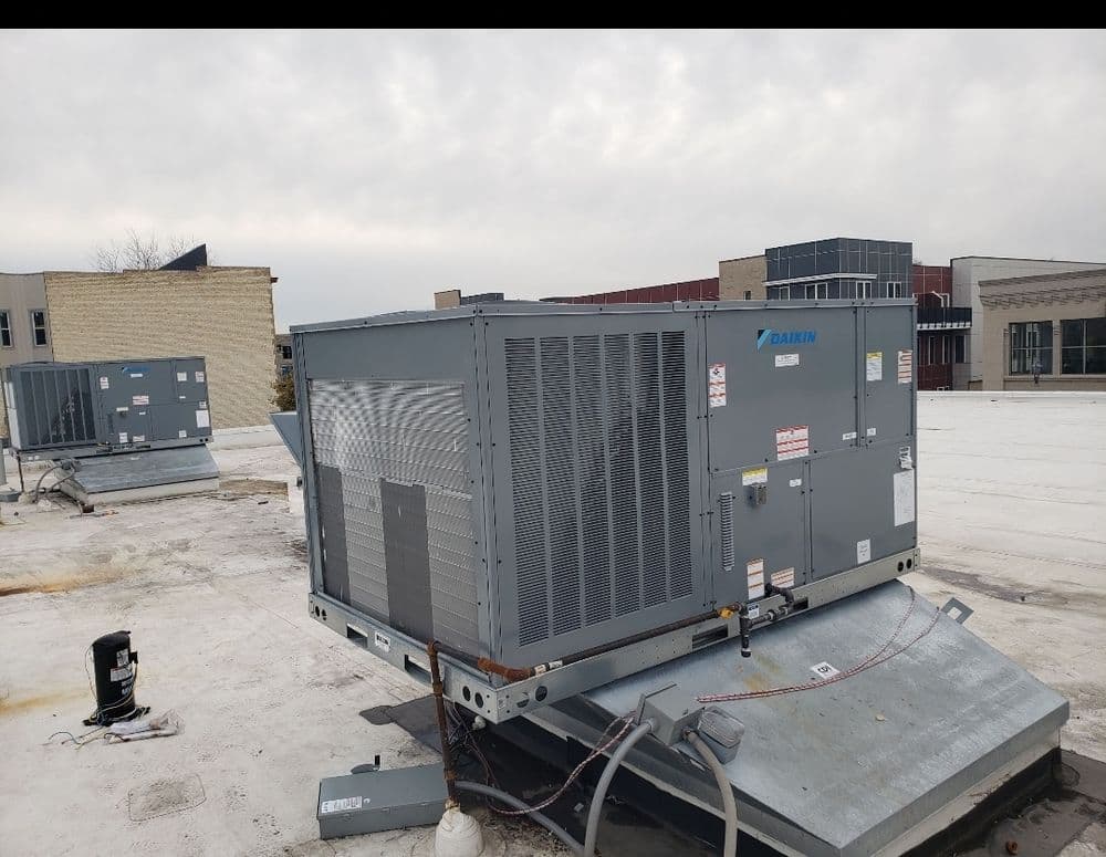 Daikin rooftop HVAC units on a commercial building, with cloudy sky in the background.